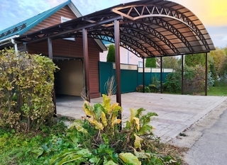 Арочный навес с поликарбонатом для стоянки авто в загородном доме